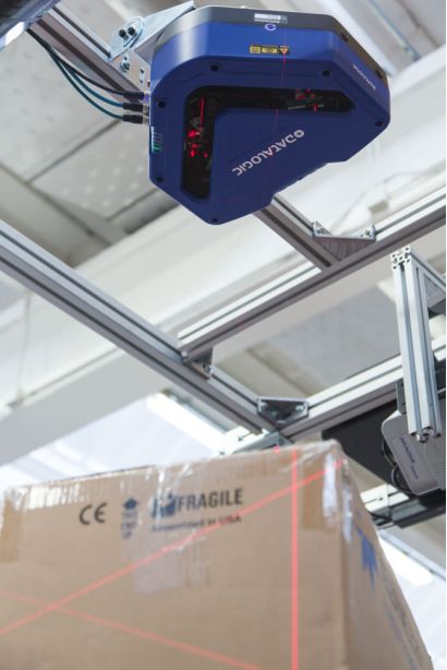 DX8210*方位條碼掃描固定式讀碼器在物流傳送帶上掃描工作時(shí)的場景展示